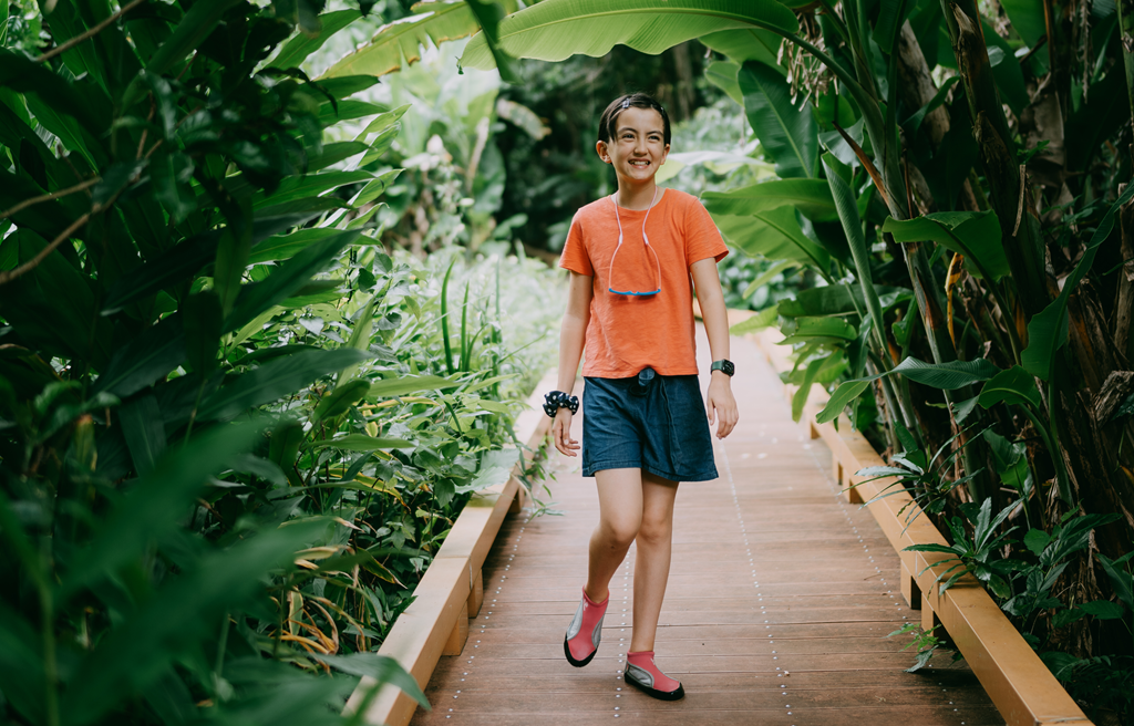 Child walking through an greenhouse garden
