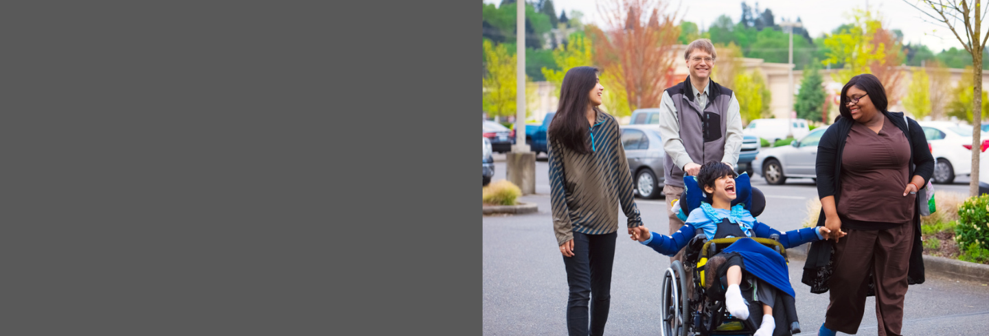 Carer and parents of boy with disabilities walking together outside