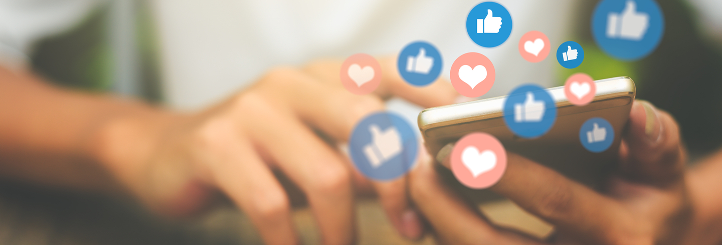 Close up of a persons hand using social media on their phone
