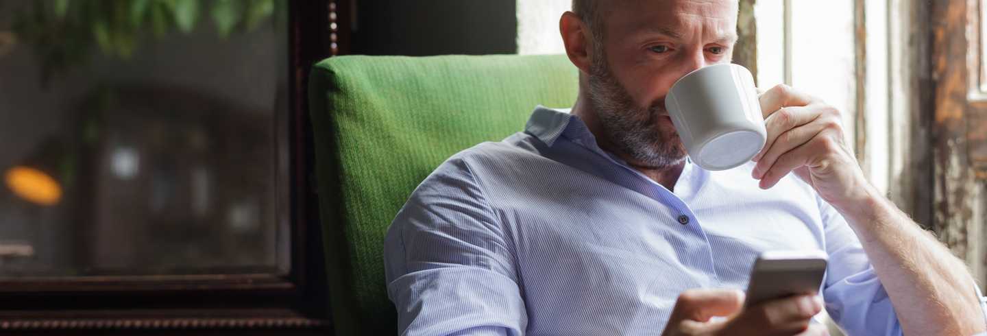 Man on phone drinking coffee