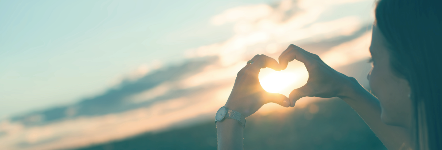 Girl with hands in teh shape of a heart